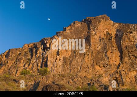 Lune au-dessus d'une falaise au coucher du soleil dans le monument naturel de Roque Nublo. Le parc rural Nublo. Tejeda. Grande Canarie. Îles Canaries. Espagne. Banque D'Images