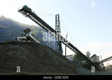 Une fosse en gravier avec des outils et des camions dans les montagnes Banque D'Images