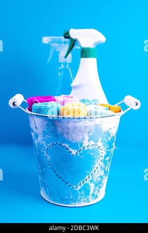 Serviettes, seau et produits de nettoyage colorés sur fond bleu. Détergent pour différentes surfaces dans la cuisine, la salle de bains et d'autres pièces. Gros plan. Banque D'Images
