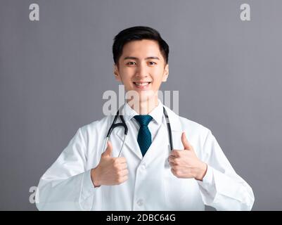 Portrait du jeune médecin asiatique masculin avec les pouces vers le haut Banque D'Images