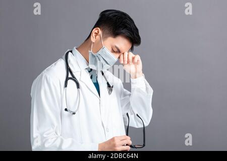 Stress et jeune médecin fatigué porter masque médical Banque D'Images