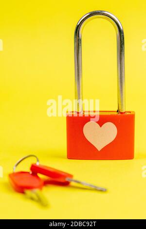 Serrure rouge avec coeur de dessin et clé sur fond jaune. Banque D'Images