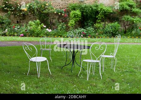 La table vide et quatre chaises blanches dans le jardin Banque D'Images