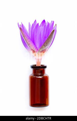 Verre de bouteille d'huile essentielle avec fleur de lotus sur fond blanc. Banque D'Images