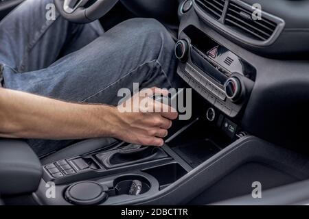 Gros plan des mains de hommes qui changent de vitesse dans la voiture Banque D'Images