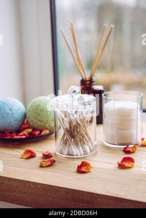 Seuil de fenêtre de salle de bains en bois naturel avec coussins en coton empilés, Q-Tips à l'intérieur des récipients d'organisation. Tampons de coton empilés, Q-Tips. Flacon diffuseur liquide. Banque D'Images