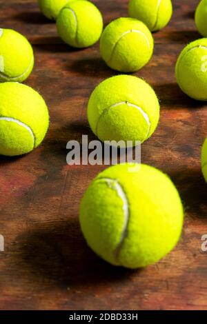 Balles de tennis en composition sur fond de bois ancien dans des tons bruns. Concept sport Banque D'Images