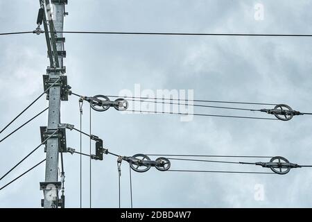 Fils de contact aériens de voies ferrées électrifiées contre un ciel sombre. Tension du fil Banque D'Images