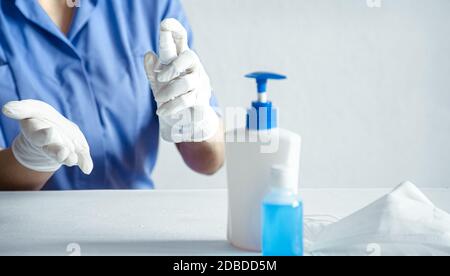 Le médecin utilise un antiseptique avec des gants blancs contre le virus Corona Covid-19. Banque D'Images