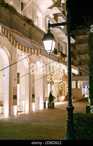 Ville nocturne avec lumières allumées et illuminations dans une maison avec entrées voûtées. Banque D'Images