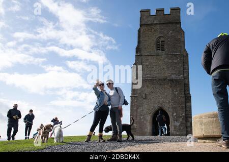 Glastonbury Tor, Somerset, Royaume-Uni. 25 octobre 2020. Les visiteurs du Glastonbury Tor dans le Somerset profitent du soleil d'automne le matin et de la température douce. Banque D'Images