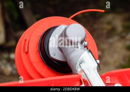 Tête avec ligne de pêche pour faucher l'herbe. Tondeuse à gaz. Gascose trimère avec une feuille pour faucher l'herbe et les arbustes. Banque D'Images