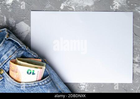 Poche d'argent en Blue Jeans avec passeport - EURO et feuille de papier blanche pour les notes sur fond gris. Banque D'Images