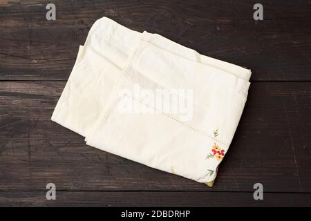 serviette de cuisine beige pliée sur une table en bois gris des vieux planches, vue de dessus, espace vide. Texture rustique. Arrière-plan rétro Banque D'Images