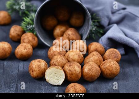 Les bonbons traditionnels allemands de Noël appelés 'Marzipankartoffeln'. Morceaux de pâte d'amandes en forme de boule ronde recouverts de cannelle et de poudre de cacao Banque D'Images