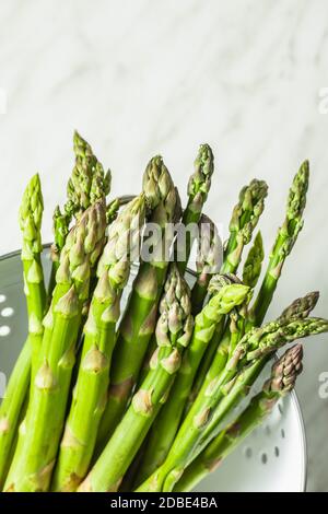 Asperges vertes fraîches. Légumes de saison sains dans la passoire. Banque D'Images