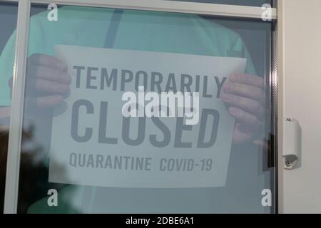 Affiche TEMPORAIREMENT FERMÉE sur une porte avant, gros plan. Restaurant fermé en raison du coronavirus. Autocollant étiqueté TEMPORAIREMENT FERMÉ. Banque D'Images