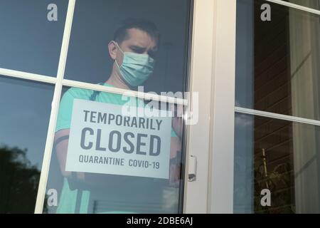 Panneau TEMPORAIREMENT FERMÉ sur une porte avant, gros plan. Fermeture temporaire de l'entreprise. Restaurant fermé en raison du coronavirus. Autocollant étiqueté TEMPORAIREMENT CL Banque D'Images