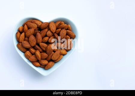 Amandes en forme de coeur sur fond blanc. Copier l'espace Banque D'Images