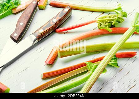 Tige de rhubarbe fraîche sur une ancienne table en bois Banque D'Images