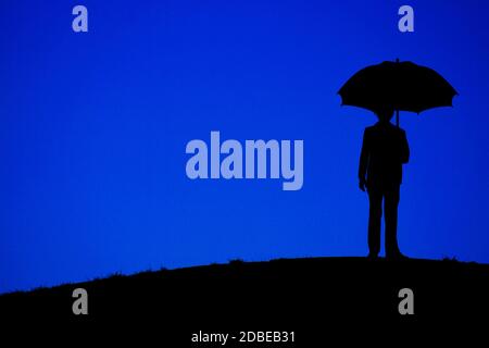 Homme tenant un support de parapluie la nuit du collines Banque D'Images