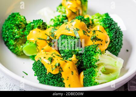 Brocoli avec sauce au fromage dans un bol blanc. Concept d'alimentation saine. Banque D'Images