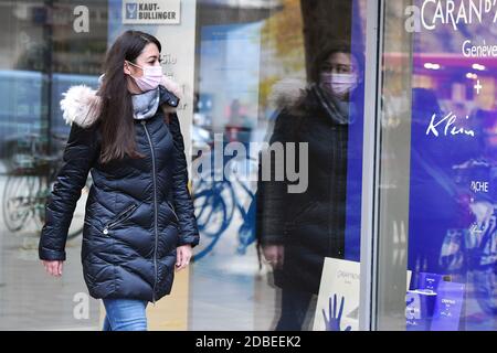 Munich, Allemagne. 17 novembre 2020. Sujet photo pandémie de coronavirus en automne/hiver-jeune femme marche avec masque facial, masque passé une fenêtre de magasin, MODÈLE LIBÉRÉ! | utilisation dans le monde crédit: dpa/Alay Live News Banque D'Images