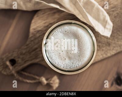 Démarreur de levain de blé. Vue de dessus du bol en verre avec démarreur à la pâte sur planche à découper en bois. Copier l'espace pour le texte ou la conception. Banque D'Images