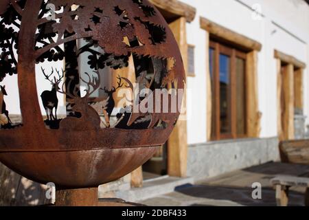 Sculpture en forme de globe en fer forgé représentant une scène de montagne avec des cerfs À l'extérieur d'un chalet dans les Alpes italiennes Banque D'Images