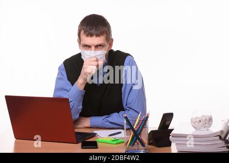 Un employé de bureau dans un masque de protection tousse dans le bureau Banque D'Images