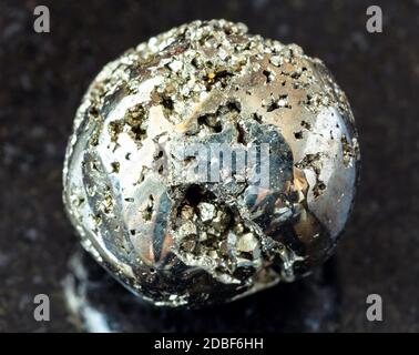 gros plan d'échantillon de minéraux naturels de la collection géologique - roche de pyrite tumbré (pyrite de fer, or de idiot) sur fond de granit noir d'Anca Banque D'Images