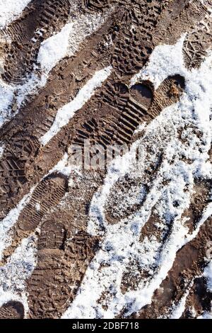 empreintes de pas sur un sentier sale couvert de neige après une chute de neige dans le parc de la ville par beau temps Banque D'Images