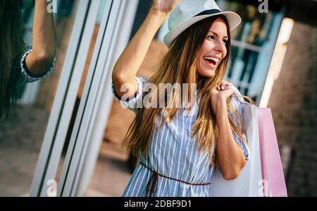 Une femme heureuse avec un sac à faire du shopping et à voyager. Consumérisme, shopping, concept de style de vie Banque D'Images