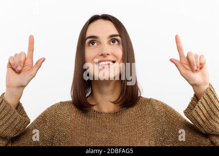 Gros plan portrait jolie jeune femme pointant avec deux doigts, regardant l'appareil photo , isolée sur fond blanc Banque D'Images