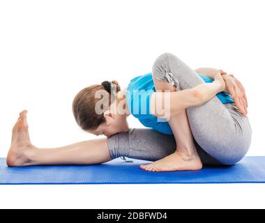 Yoga - jeune belle femme mince instructeur de yoga faire avant Courbes Sage Twist A pose (Marichyasana A) asana exercice isolé sur fond blanc Banque D'Images