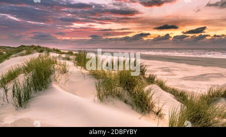 Coucher de soleil vue depuis une dune au-dessus de la mer du Nord de l'île d'Ameland, Frise, Pays-Bas Banque D'Images