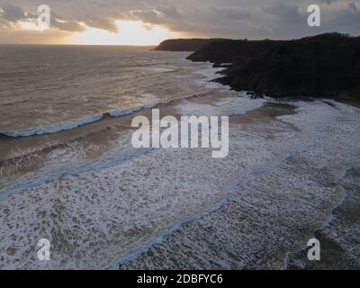 Tir de drone d'UN coucher de soleil à Caswell Bay à Gower, pays de Galles, Royaume-Uni. Mousses, avec des couleurs intéressantes dans les nuages Banque D'Images