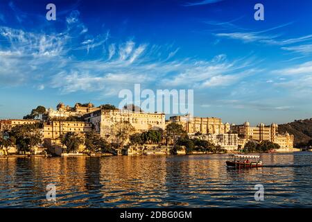 Palais de la ville et bateau touristique sur le lac Pichola au coucher du soleil. Udaipur, Rajasthan, Inde Banque D'Images