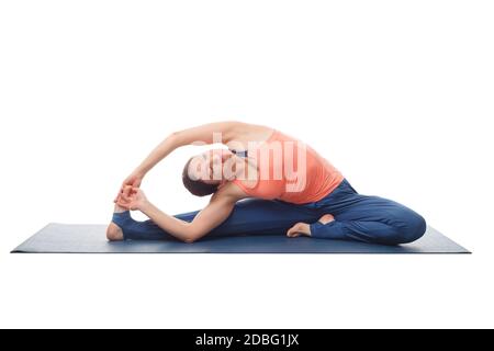 Belle tenue sportive yogini femme pratique yoga asana parivrtta janu sirsasana - posture de la tête au genou avec révolution isolée sur fond blanc Banque D'Images