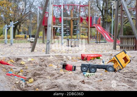 Terrain de jeu déserté dans un parc de la ville avec des jouets cassés pour enfants pendant le confinement de COVID-19. Restrictions de distance sociale du virus Corona. Stationnement vide. Banque D'Images