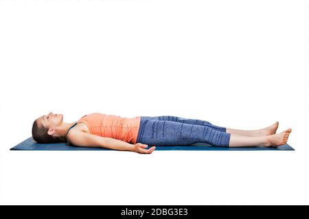 Belle femme sportive de forme yogini se détend dans le yoga asana Savasana - pose de cadavre en studio Banque D'Images