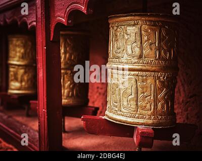 Vintage rétro effet filtre hipster image de style de la prière bouddhiste roues dans Thiksey gompa (le monastère bouddhiste tibétain). Ladakh, Inde Banque D'Images
