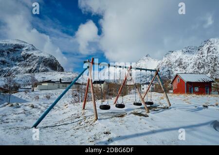 Aire de jeux pour enfants avec balançoires faites de pneus de voiture en hiver. Un village, îles Lofoten, Norvège Banque D'Images