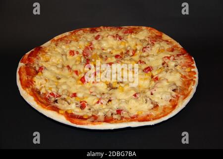 Tranches de pizza appétissants frais avec de délicieux ingrédients sur la plaque de couleur sur fond noir. Pizza savoureuse sur la plaque isolé sur fond noir. Banque D'Images