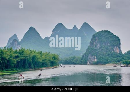 Bateaux de tourisme sur la rivière Li avec paysage spectaculaire de montagne karst en arrière-plan. Yangshuo, Chine Banque D'Images
