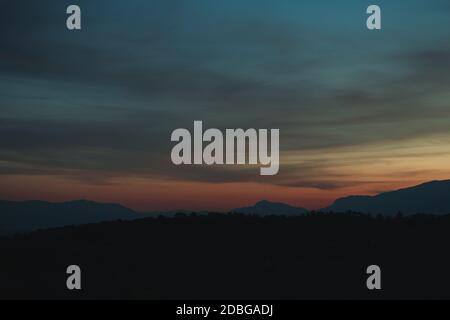 Vue sur le paysage du coucher de soleil en automne avec les montagnes et la clôture et feu de route Banque D'Images