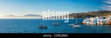 Coucher de soleil sur l'île de Mykonos, Grèce avec yachts dans le port et maisons colorées en bord de mer de la petite Venise endroit romantique sur le coucher du soleil et bateau de croisière. Mon Banque D'Images