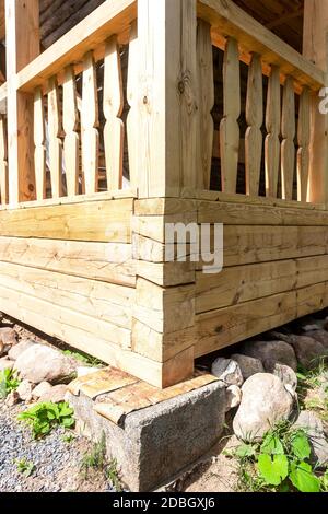 Coin de la maison en bois sur la base de pierre de support Banque D'Images