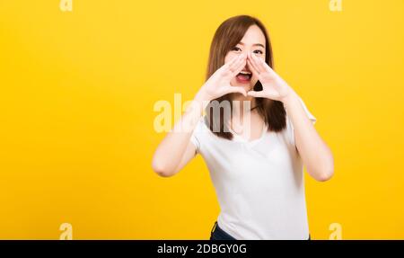 Portrait heureux asiatique belle jeune femme jeune ado se tenant grand shout avec les mains à la bouche suivante donnant excité positif regardant l'appareil photo isolé, Banque D'Images