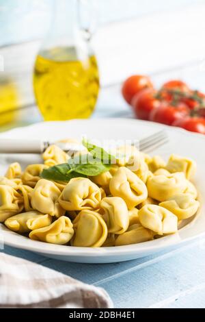 Pâtes tortellini. Pâtes italiennes farcies aux feuilles de basilic dans un plat. Banque D'Images